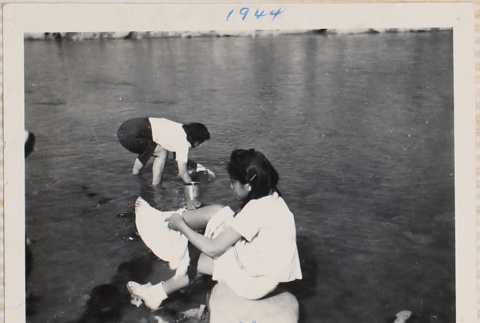 Two women in shallow river edge (ddr-densho-464-68)