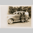 Man and woman standing next to car, woman in driver's seat (ddr-densho-426-1852)