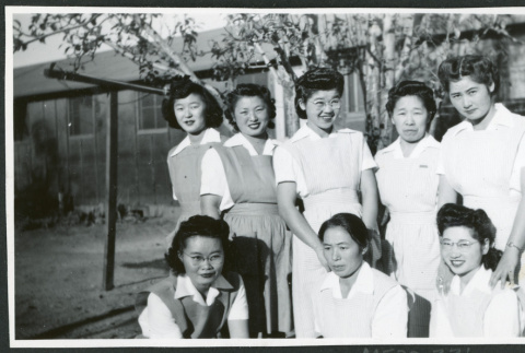 Photograph of eight hospital staff aides posing in front of the Manzanar hospital (ddr-csujad-47-195)
