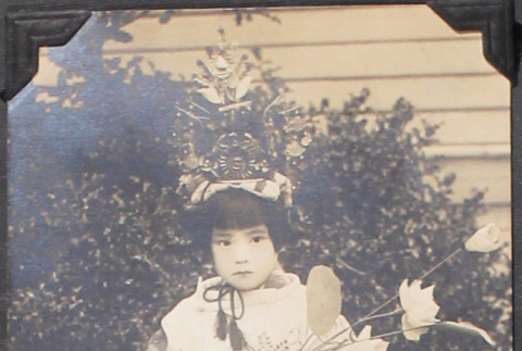 Young girl in costume holding flowers (ddr-densho-493-179)