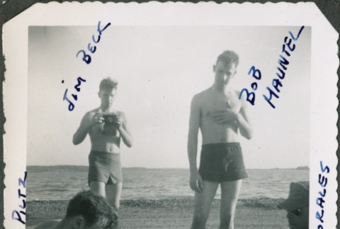 Man with camera stands near otehrs on beach (ddr-densho-321-384)