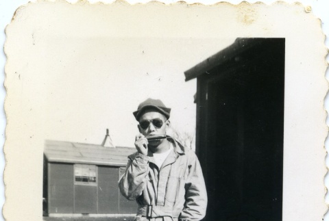 Soldier playing a harmonica (ddr-densho-22-409)