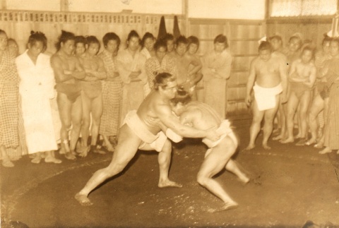 Two sumo wrestlers fighting while others look on (ddr-njpa-4-9)