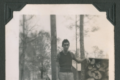 Man by log pile (ddr-densho-471-57)