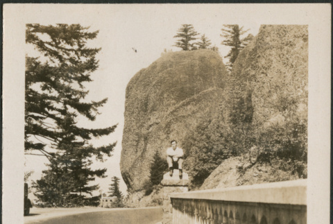 Man sitting on railing alongside road (ddr-densho-316-236)