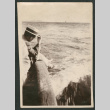Photo of a man sitting on rocks beside open water (ddr-densho-483-235)