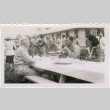 Four people seated at a picnic table (ddr-densho-434-509)