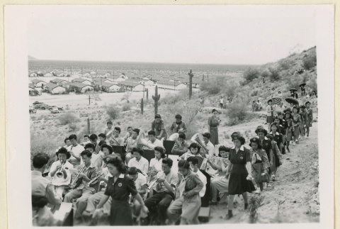 Girl Scouts proceed past a performing band (ddr-densho-37-1143)