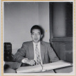 Man sitting at a desk with notebook (ddr-densho-522-22)
