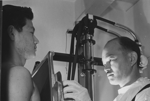 Former Californian Dr. Fugikawa examining a patient (ddr-csujad-14-14)