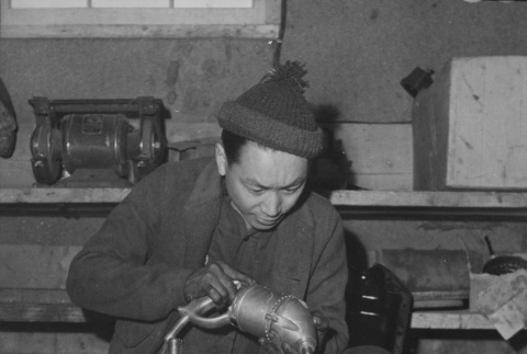 Mechanic honing cylinders in a truck motor at Heart Mountain incarceration camp (ddr-csujad-14-53)
