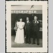 A woman and two men in front of a photography studio (ddr-densho-298-294)