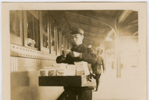 Man outside train, carrying box (ddr-densho-426-1386)