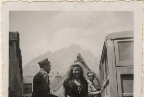 Woman standing by tents and army vehicles (ddr-densho-466-412)