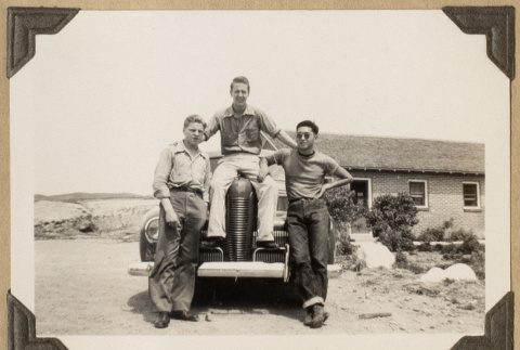 Roy Sumida and two others on a car (ddr-densho-542-458)