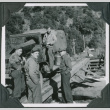 Four men standing by truck on bridge (ddr-ajah-2-375)