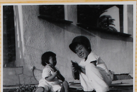 Susan Shiomi with William  Shiomi showing her how to play with a toy gun (ddr-densho-522-270)