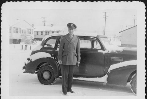 Man standing by car in snow (ddr-densho-434-379)