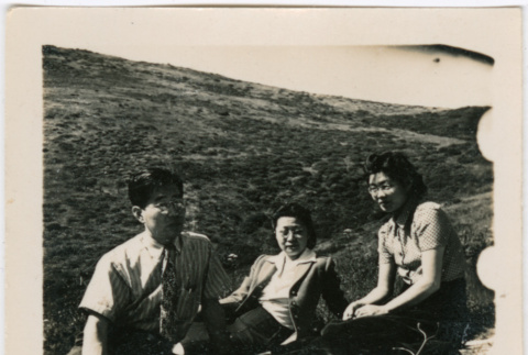 Henri Takahashi (l), unknown women and Tomoye (Nozawa) Takahashi sitting in a field (ddr-densho-426-1944)