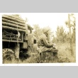 Soldier smoking on a tree stump (ddr-densho-22-204)