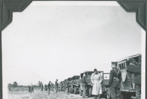Men standing next to row of trucks (ddr-ajah-2-207)