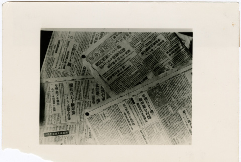 Stack of newspapers about enemy plane attacks (ddr-densho-381-115)
