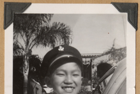 Boy smiling by a car (ddr-densho-542-208)