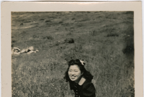 Tomoye (Nozawa) Takahashi sitting in a field (ddr-densho-426-1942)