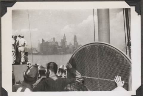 Men on ship looking at New York skyline (ddr-densho-466-171)