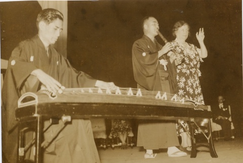 Helen Keller on state with a man playing a koto and another playing a fue. (ddr-njpa-1-758)