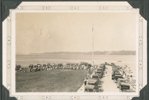 Line of cars and large group near shore (ddr-densho-316-292)