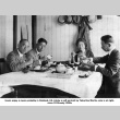 Three men and woman sitting at a table eating (ddr-ajah-6-556)