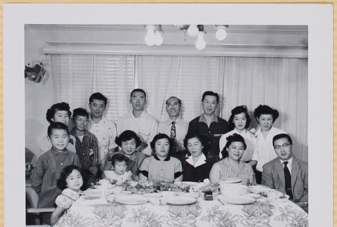 Group of adults and children posing by dinner table (ddr-densho-522-553)