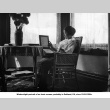Woman seated by window holding photo album (ddr-ajah-6-560)