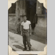 Man outside building doorway with boy in background (ddr-densho-466-748)