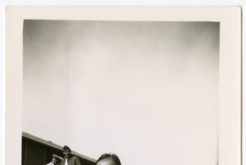Toddler with couple in background outside barracks (ddr-densho-329-1336)