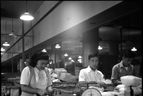 Three people packing items for shipping (ddr-densho-426-947)