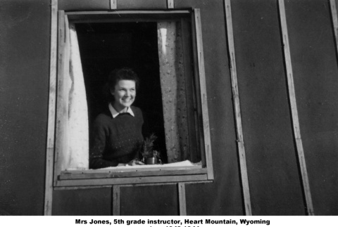 Woman looking out of barracks window (ddr-ajah-2-909)