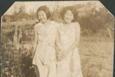 Two young women standing in field (ddr-densho-316-179)
