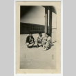 Nisei men sitting outside with building in the background (ddr-csujad-44-6)