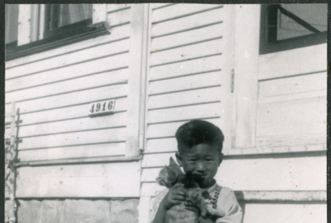 Boy sitting on steps holding cat (ddr-densho-523-246)