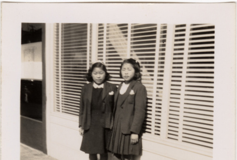 Two girls standing outside business (ddr-densho-426-27)