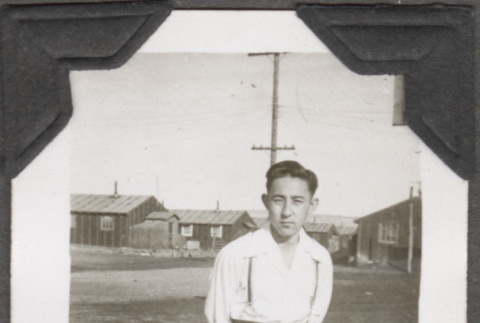 Man standing with barracks in background (ddr-densho-466-199)