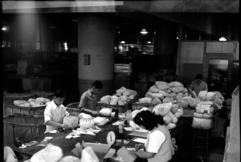 Four people packing items for shipping (ddr-densho-426-949)
