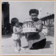 Yoshiko Shiomi holding a cake with Susan Shiomi (ddr-densho-522-241)