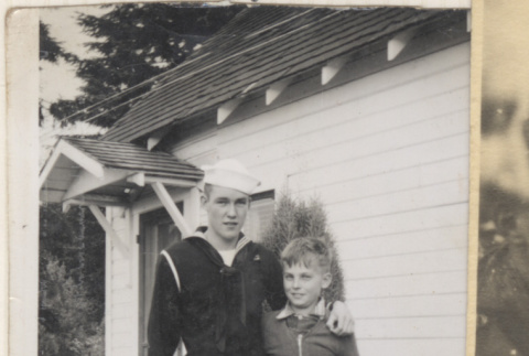Man in sailor's uniform standing with young boy (ddr-densho-466-338)
