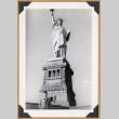 Man posing beside the Statue of Liberty (ddr-densho-542-335)