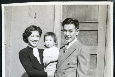 Photograph of Jean and Togo Tanaka with daughter Iye posing in front of a door in Cow Creek Camp in Death Valley (ddr-csujad-47-130)