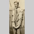 Claude A. Swanson wearing leis on the deck of a ship (ddr-njpa-1-1946)