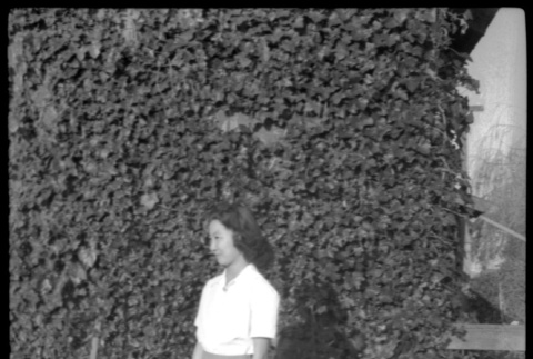 Mae Miwa standing for photo in front of ivy-colored wall (ddr-densho-475-94)